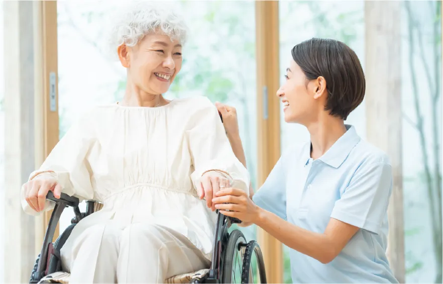 車椅子の高齢者と介護人の写真