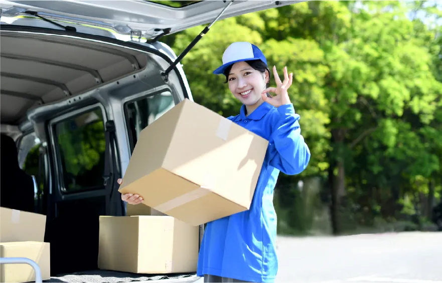 ダンボールを車に積む女性の写真