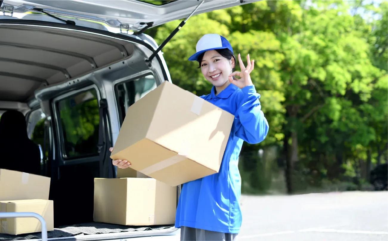 ダンボールを車に積む女性の写真