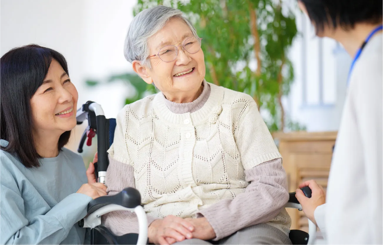車椅子の高齢者と家族の写真