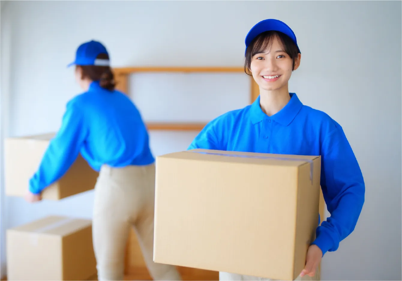 ダンボールを持っている女性スタッフの写真